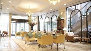 A spacious lobby with a high ceiling, large windows, and a grand staircase. - Hotel Rose Garden Shinjuku (Tokyo)