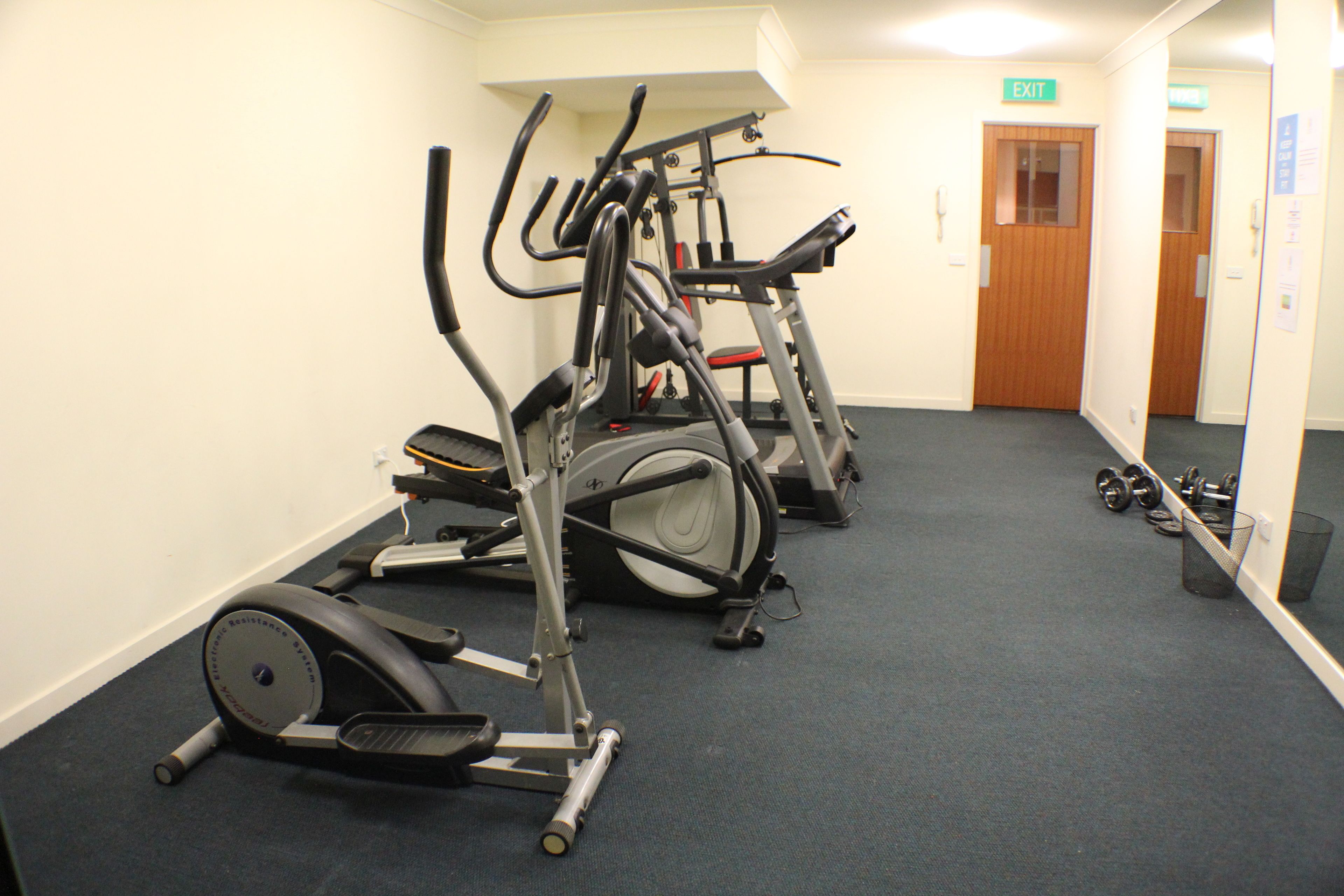 A gym with stationary bikes and dumbbells.