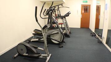 A gym with stationary bikes and dumbbells.