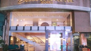The Executive Hotel Manila's exterior with a prominent entrance, a staircase leading to the upper level, and a visible sign indicating no parking.