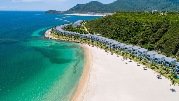 Une station balnéaire dotée de villas en bord de mer, d’eaux turquoise cristallines et d’une végétation luxuriante.