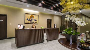 A reception desk with a sign reading "AKOYA SPA".