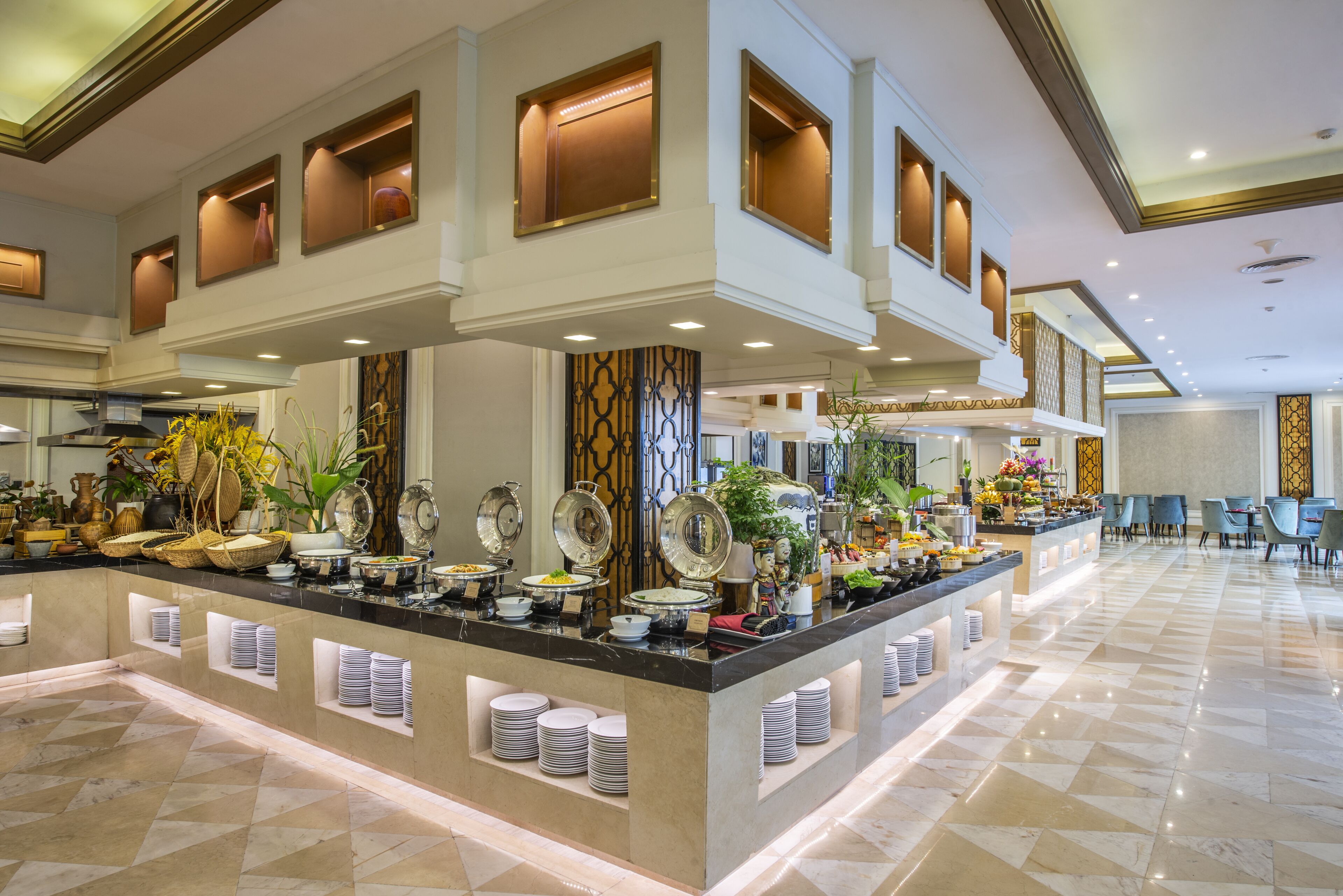 A buffet area with a central island, multiple serving stations, and a check-in counter.