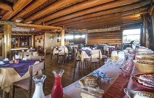 Un interior rústico de madera con varias mesas dispuestas para un bufé, que incluye diversos alimentos y bebidas.