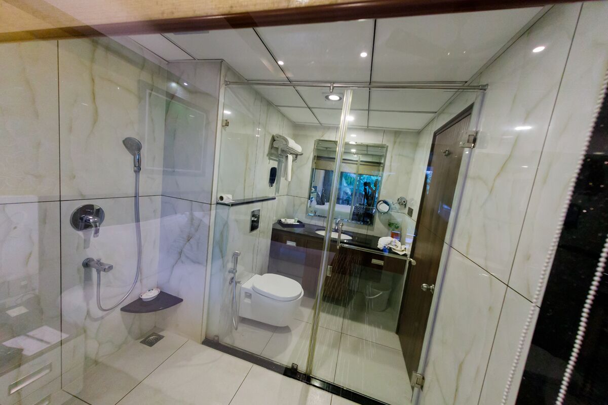 Un baño moderno con ducha envuelta en vidrio, inodoro y lavamanos.
