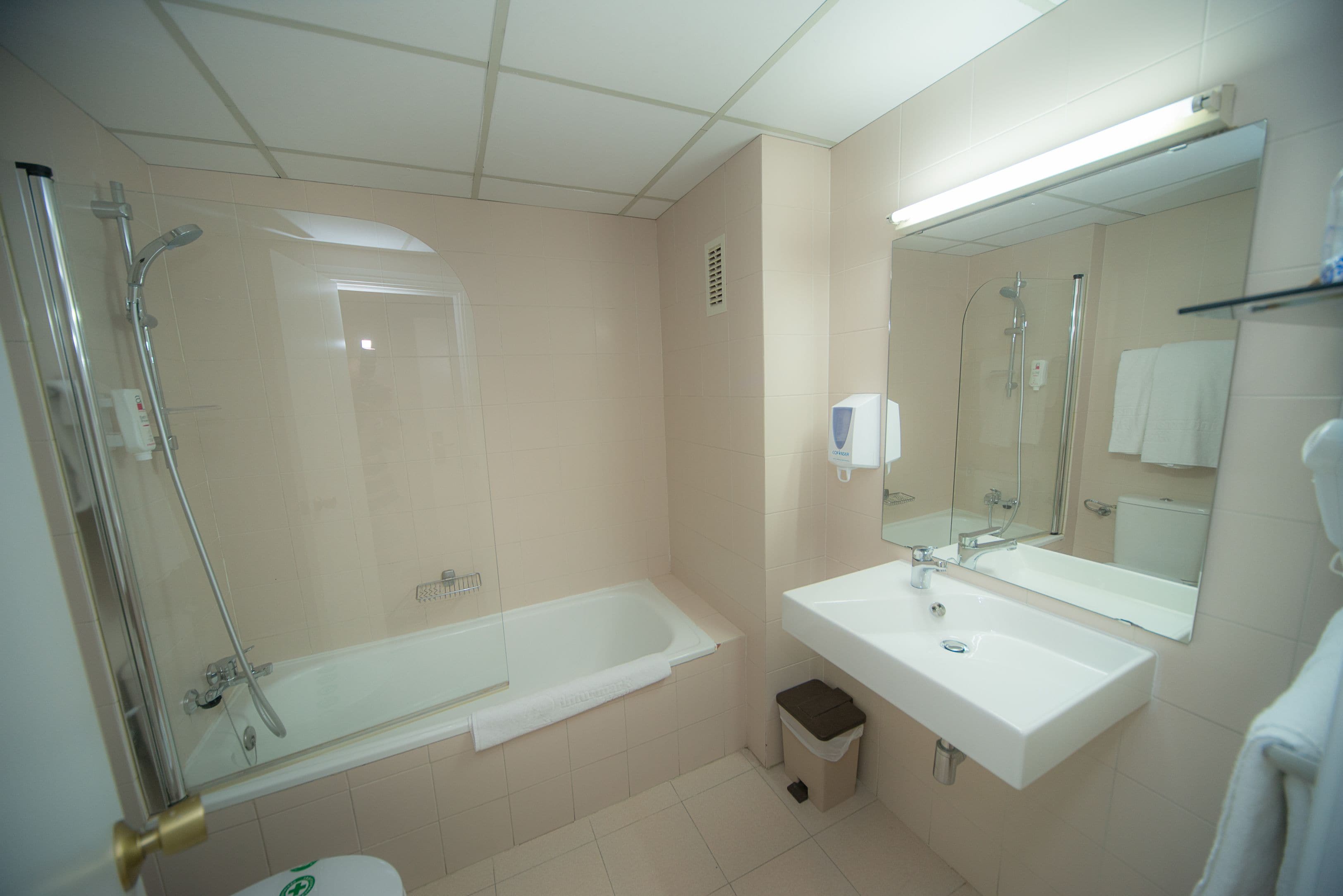 A bathroom with a bathtub, shower, sink, and toilet.