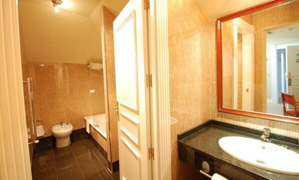 Un baño de hotel con bidé, inodoro y lavamanos.