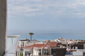 A coastal cityscape with buildings and a palm tree. - Ibersol Playa Dorada (El Vendrell)
