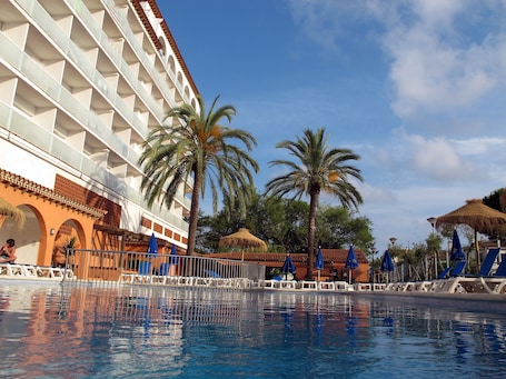 Una piscina al aire libre, sombrillas, sillones reclinables de piscina. Ibersol Playa Dorada