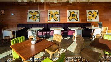 Un restaurante con una pared de madera, una cabina morada y varias mesas y sillas.
