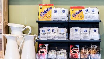 A display of coffee and tea products including Nescafe and Coca Cola branded items.