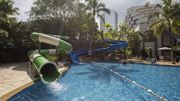 Relax by the pool surrounded by palm trees and enjoy the views from the building's balconies.