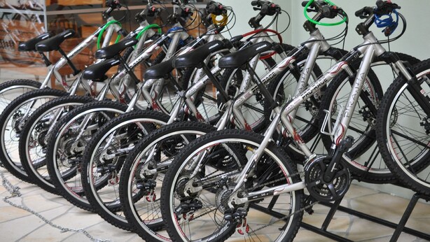 Une rangée de vélos est garée à l’intérieur, probablement dans un espace ou un bâtiment public.