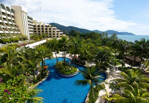 A resort with a large pool surrounded by palm trees and a view of the ocean. - PARKROYAL Penang Resort (George Town)