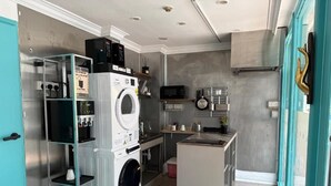 Een compacte keuken met een ingebouwde wasmachine, een magnetron en een klein kookeiland.