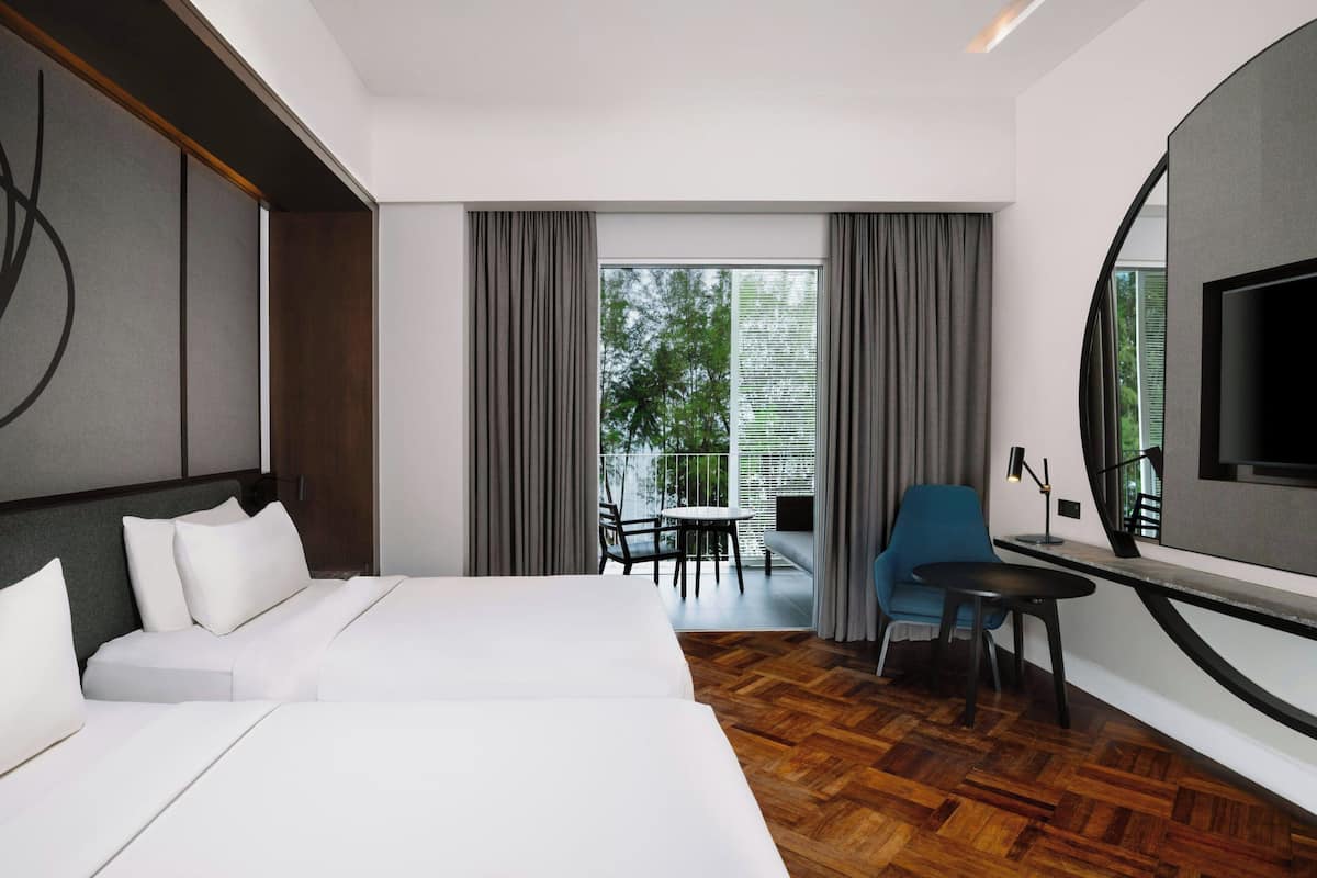 Une chambre d’hôtel avec un grand lit, un bureau, une chaise et un téléviseur.