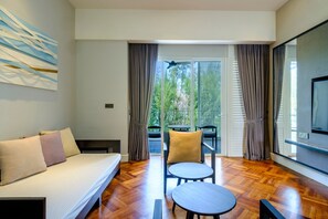 Relax in a spacious room with a large bed, flat-screen TV, and a small table for work or relaxation.