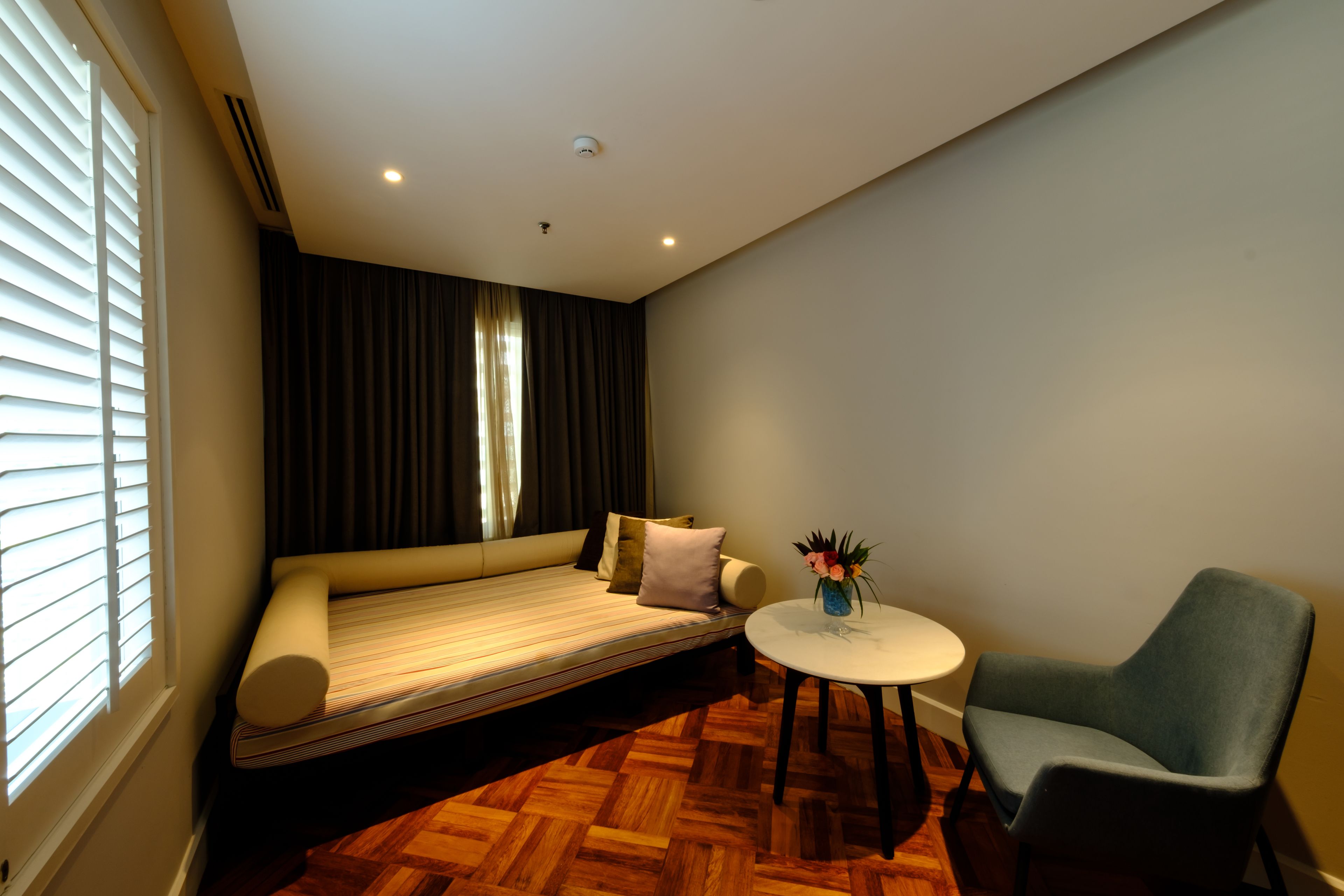A modern room with a sofa, a small table, and a chair.