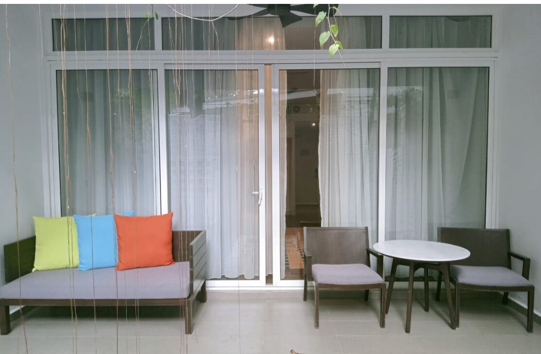 A room with a sofa, two chairs, a table, and a sliding glass door.