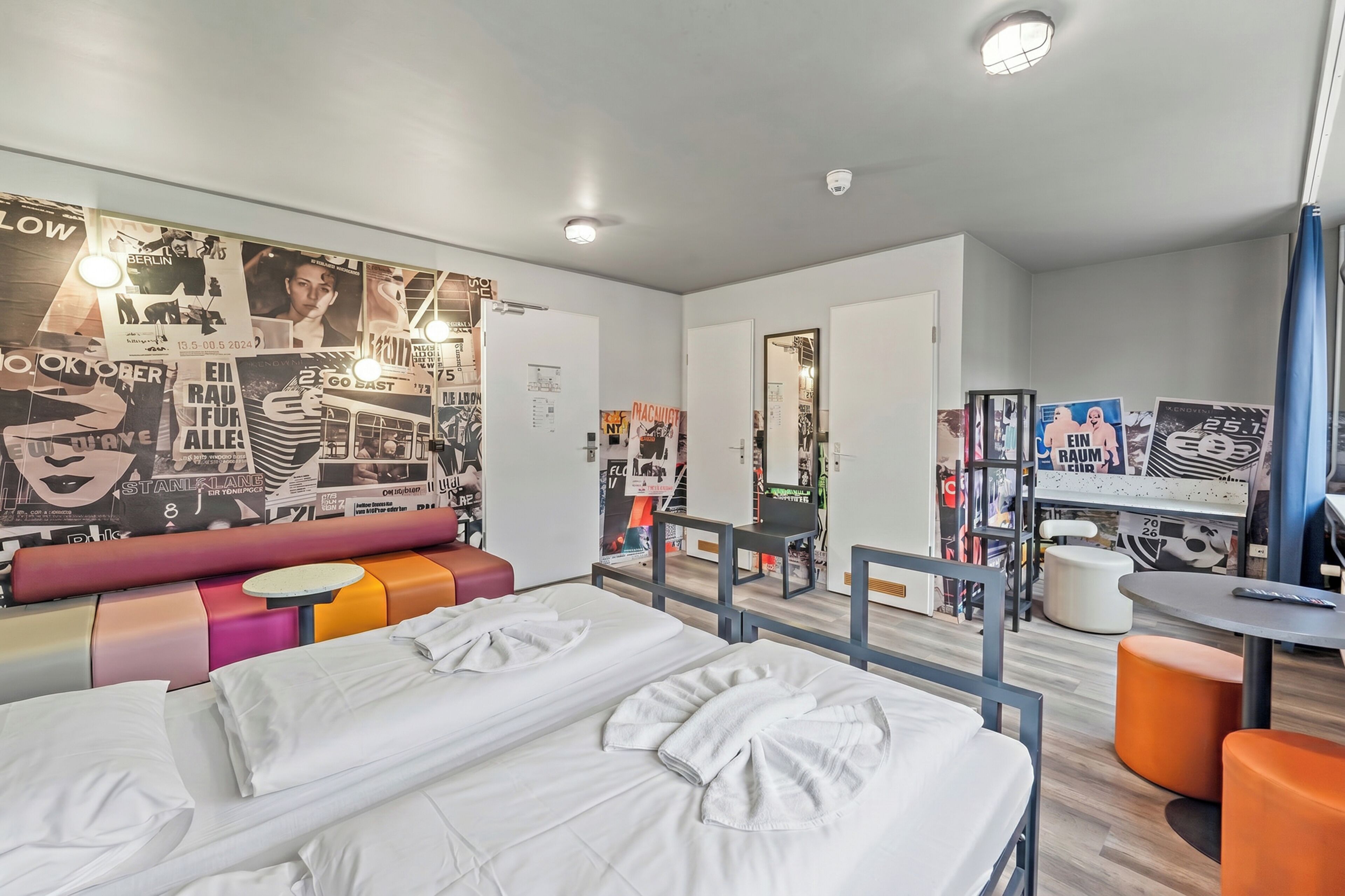 Une chambre d’hôtel moderne équipée d’un lit, d’un coin salon et d’un bureau.
