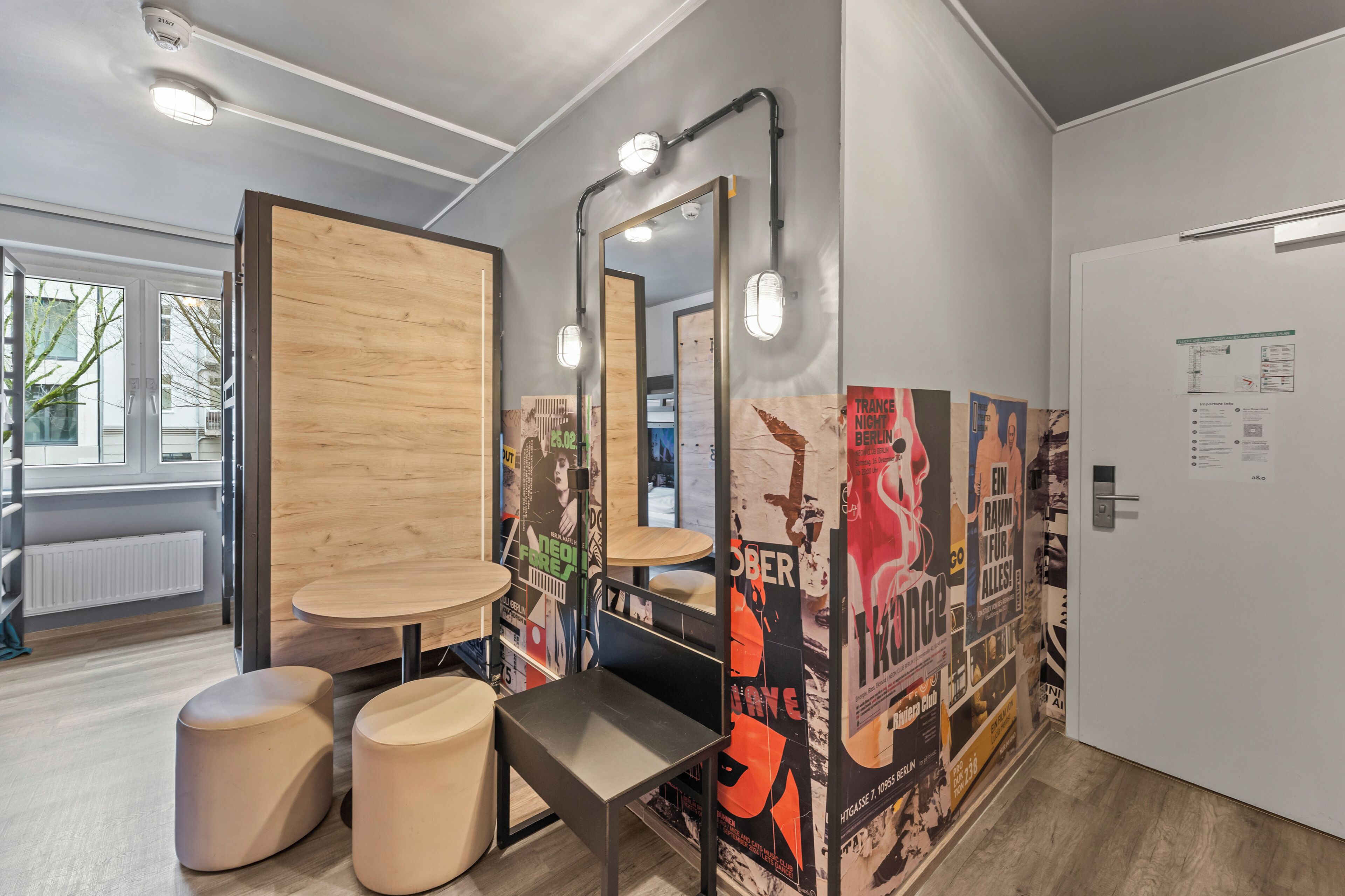 Een moderne badkamer met houten details, een spiegel en posters aan de wand.
