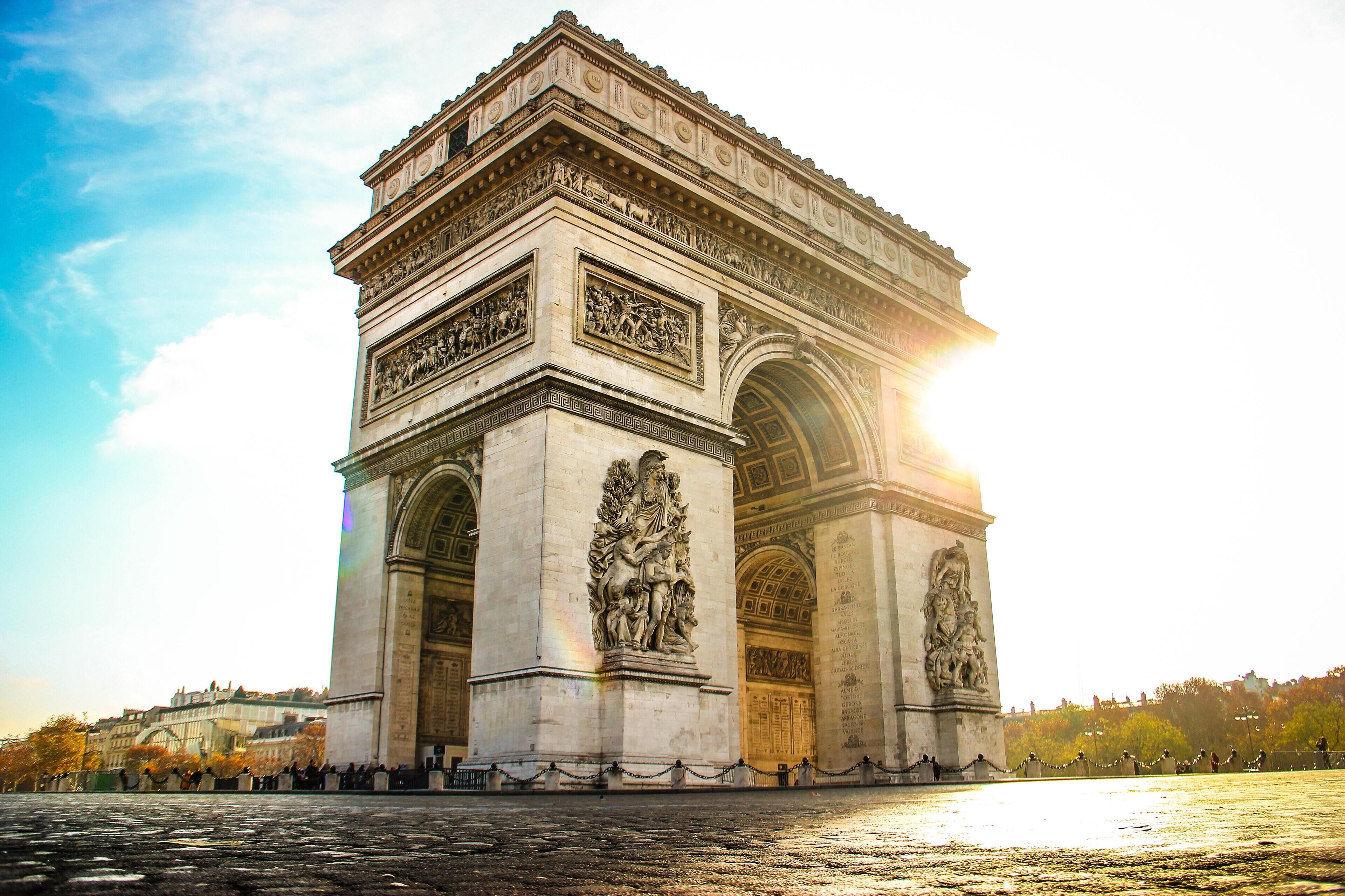 A large stone monument with intricate carvings and statues, surrounded by a cobblestone area.
