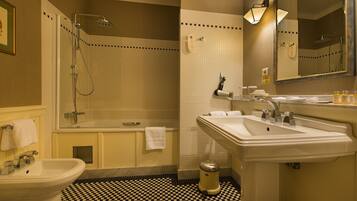 Een badkamer met een wastafel, spiegel en douche.