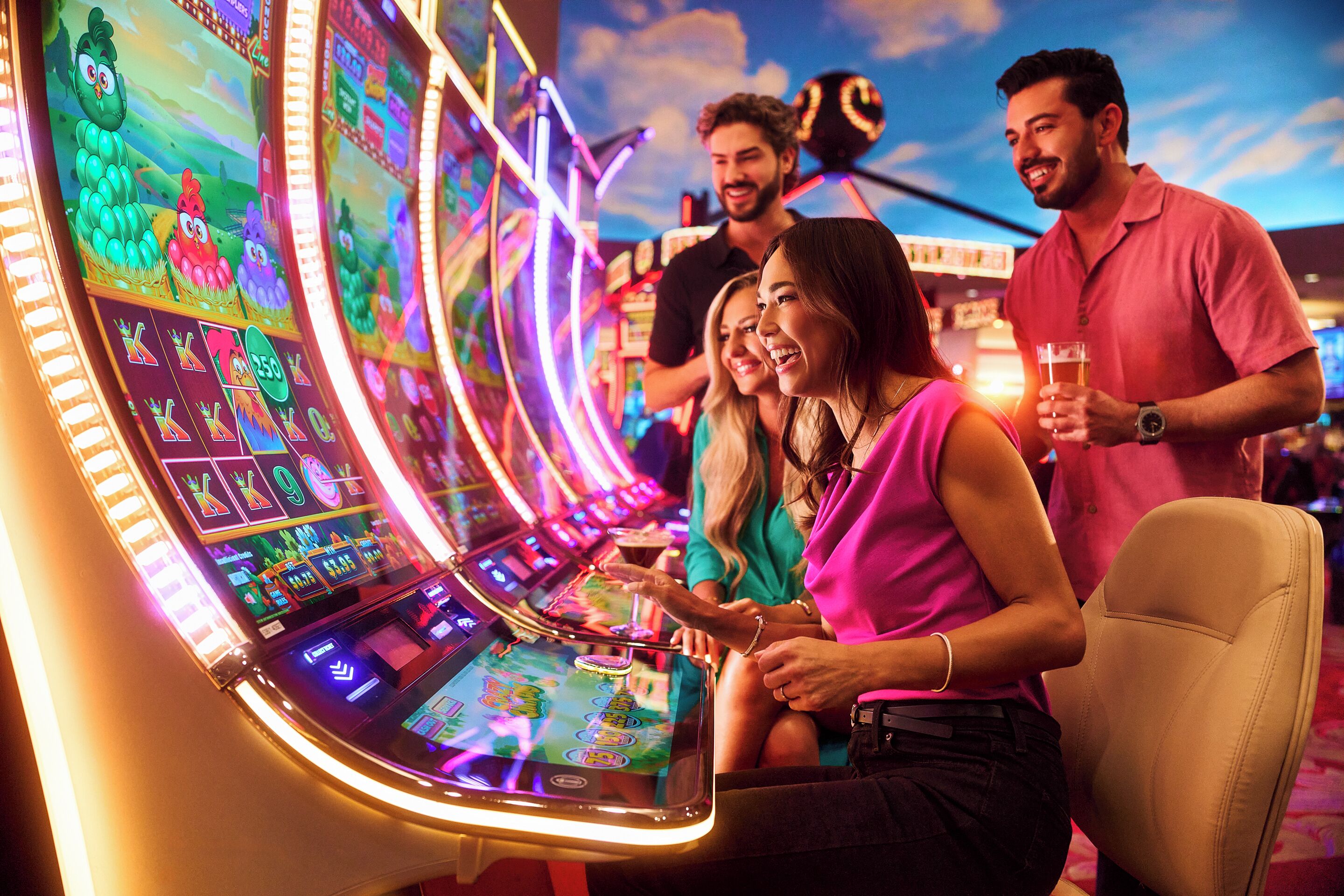 A slot machine area with illuminated screens and a person playing.