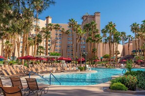 A hotel pool area with sun loungers, palm trees, and a large building in the background. - CasaBlanca Resort, Casino, Golf & Spa (Mesquite)