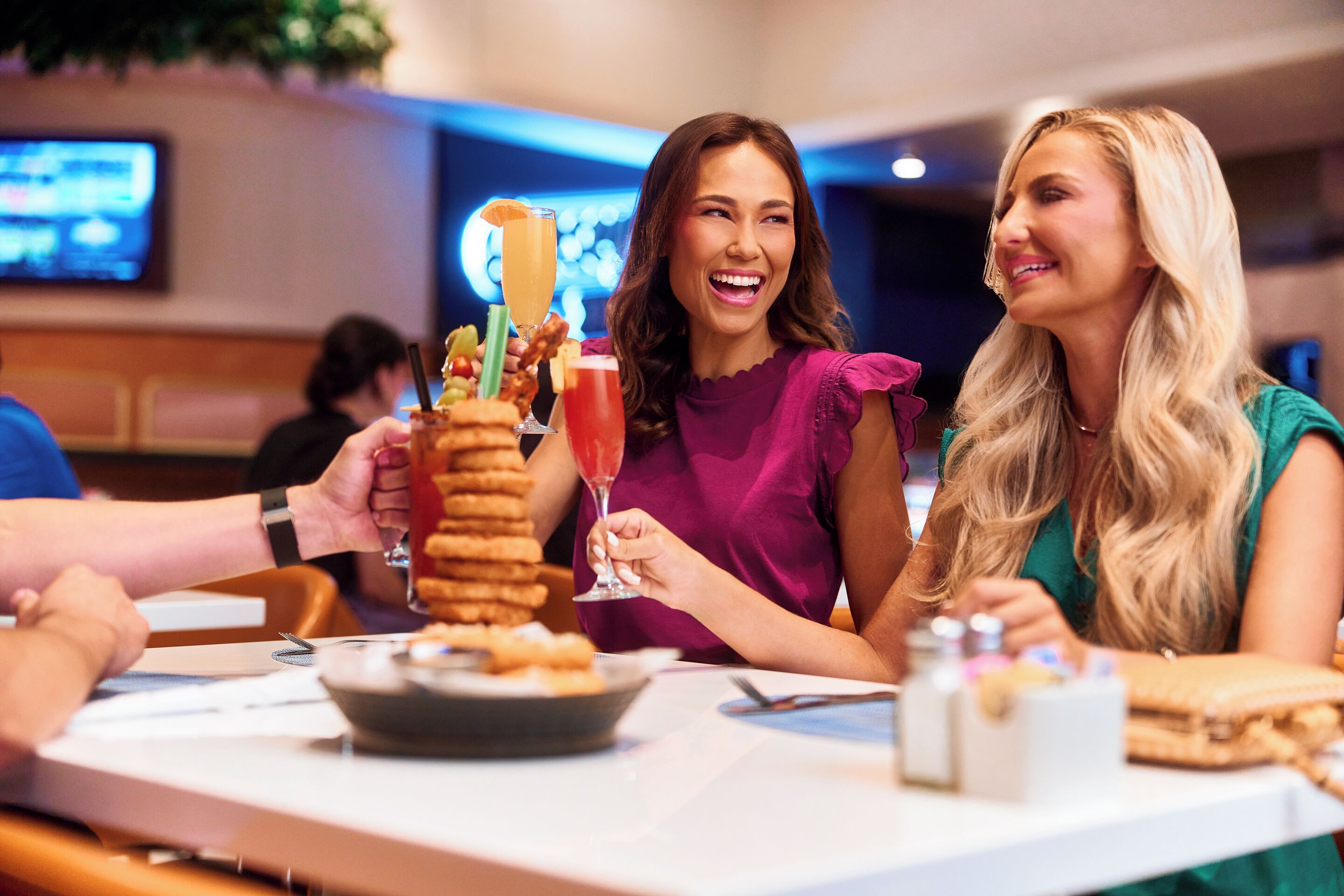 Un grupo de personas sentadas en una mesa con diversos alimentos y bebidas.