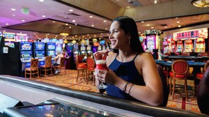 Eine Frau an der Casino-Bar hält ein Getränk.