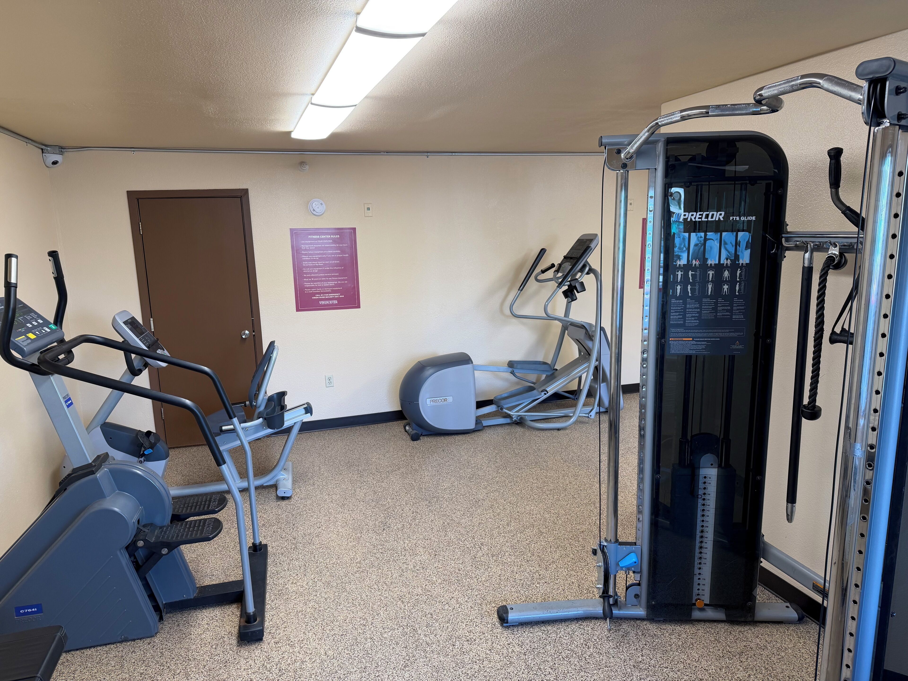 Ett träningscenter med konditionsmaskiner, en trappmaskin och en styrketräningsmaskin.