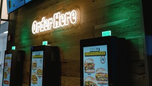 Une enseigne Burger King avec un panneau néon indiquant « Commandez ici » en dessous.