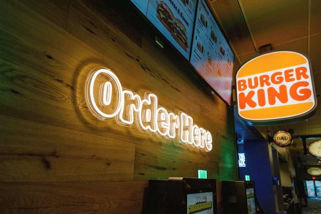 A Burger King sign with a neon 'Order Here' sign above it.