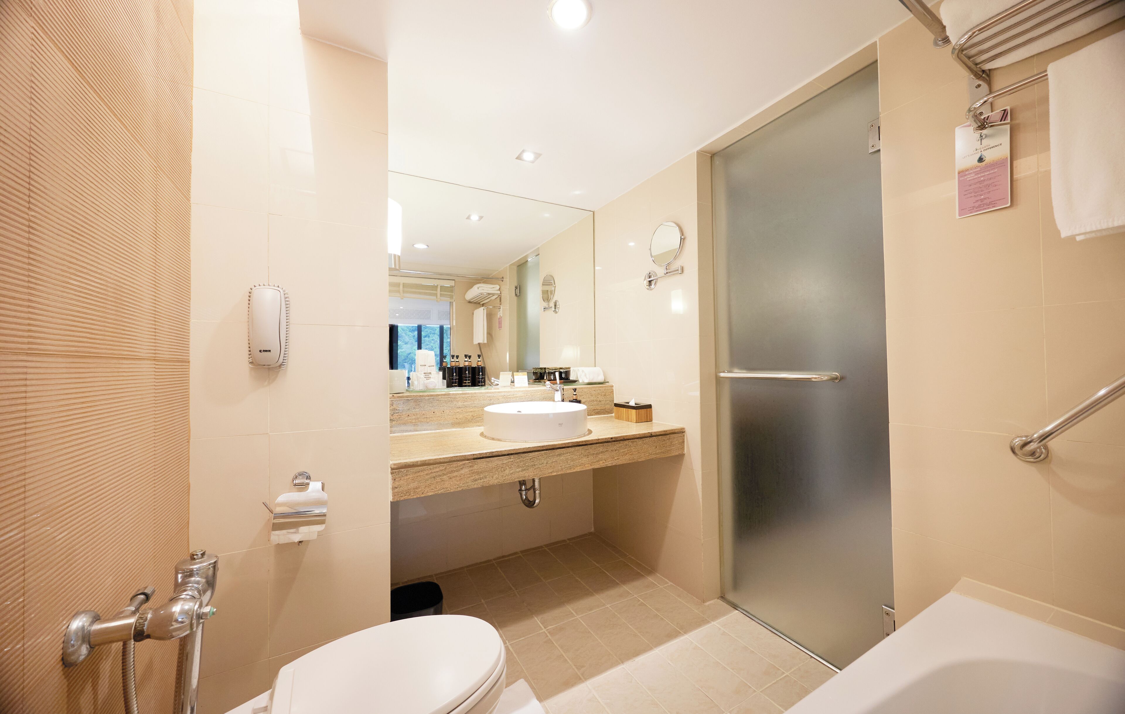 A modern bathroom with a toilet, sink, and bathtub.