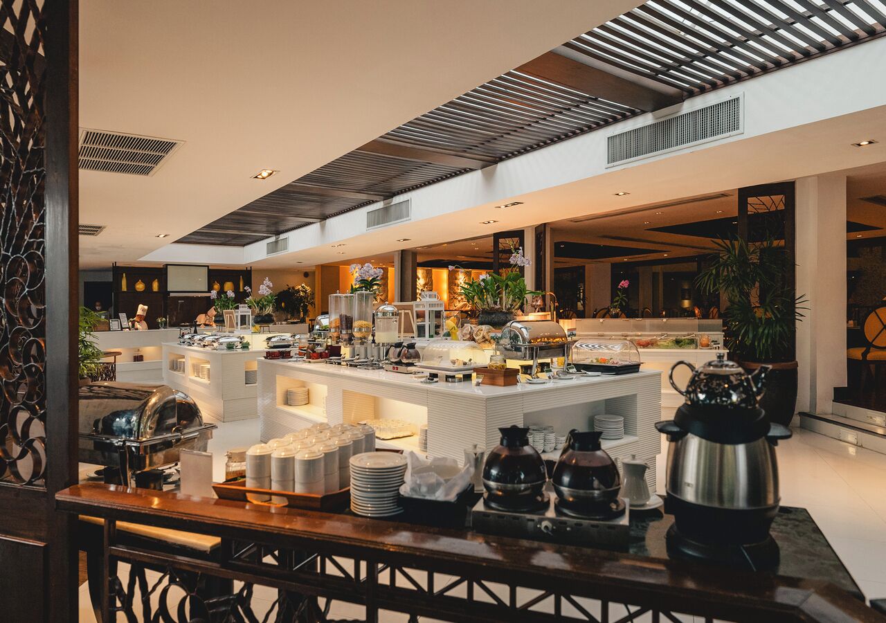 A buffet setup with various food items and kitchenware.