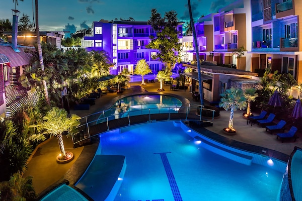 Een buitenzwembad, parasols voor strand/zwembad