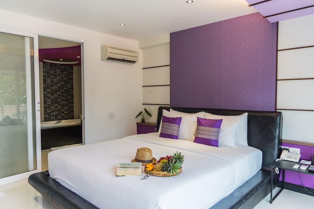 Una habitación de hotel moderna con cama, un escritorio pequeño y un baño con ducha.