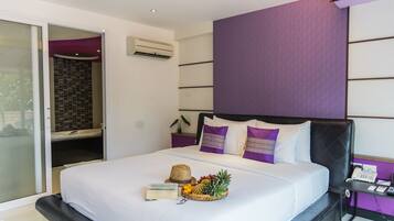 Een moderne hotelkamer met een bed, een bureau en een badkamer met douche.