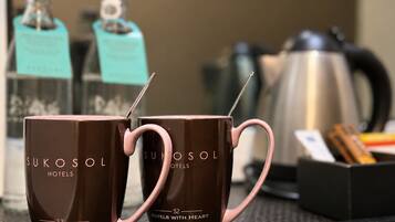 Two brown mugs with pink handles and the text 'SUKOSOL HOTELS' on a table.