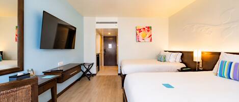 A hotel room with a bed, a desk, a chair, a television, and a door leading to a bathroom.