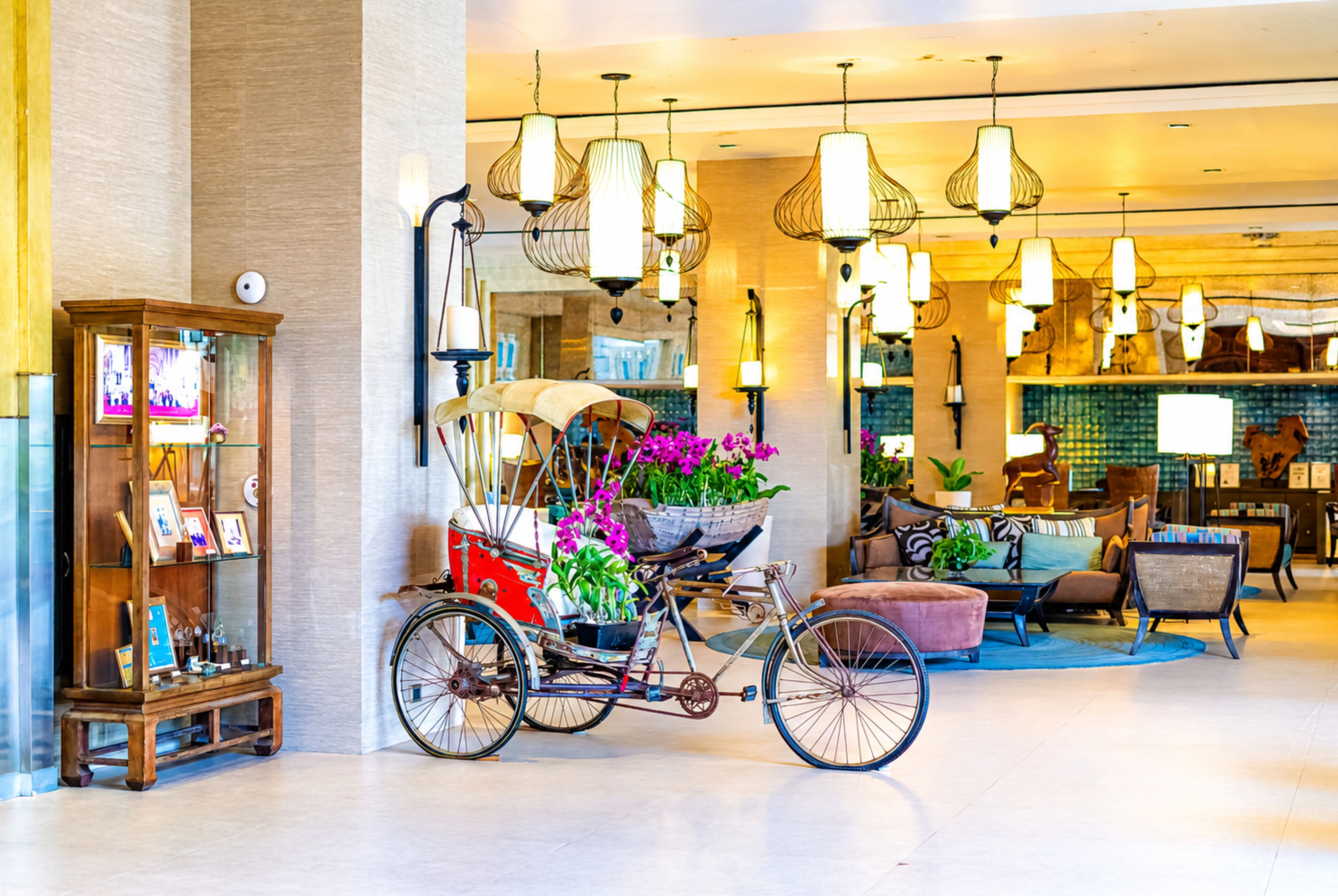 A spacious lobby with a bicycle cart, a wooden display cabinet, and hanging pendant lights.