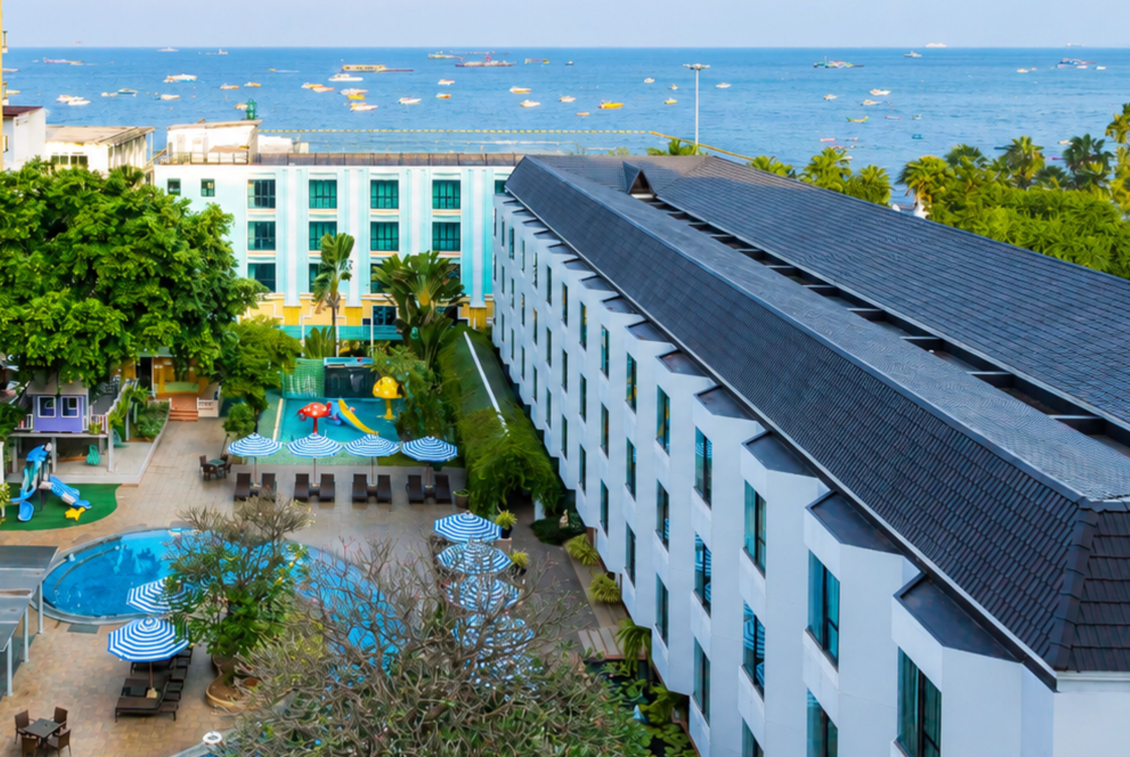 Un albergo con piscina, lettini e vista sull'oceano.