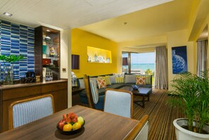 A hotel room with a dining area, a seating area with a view, and a large potted plant. - The Bayview Hotel Pattaya (Pattaya)