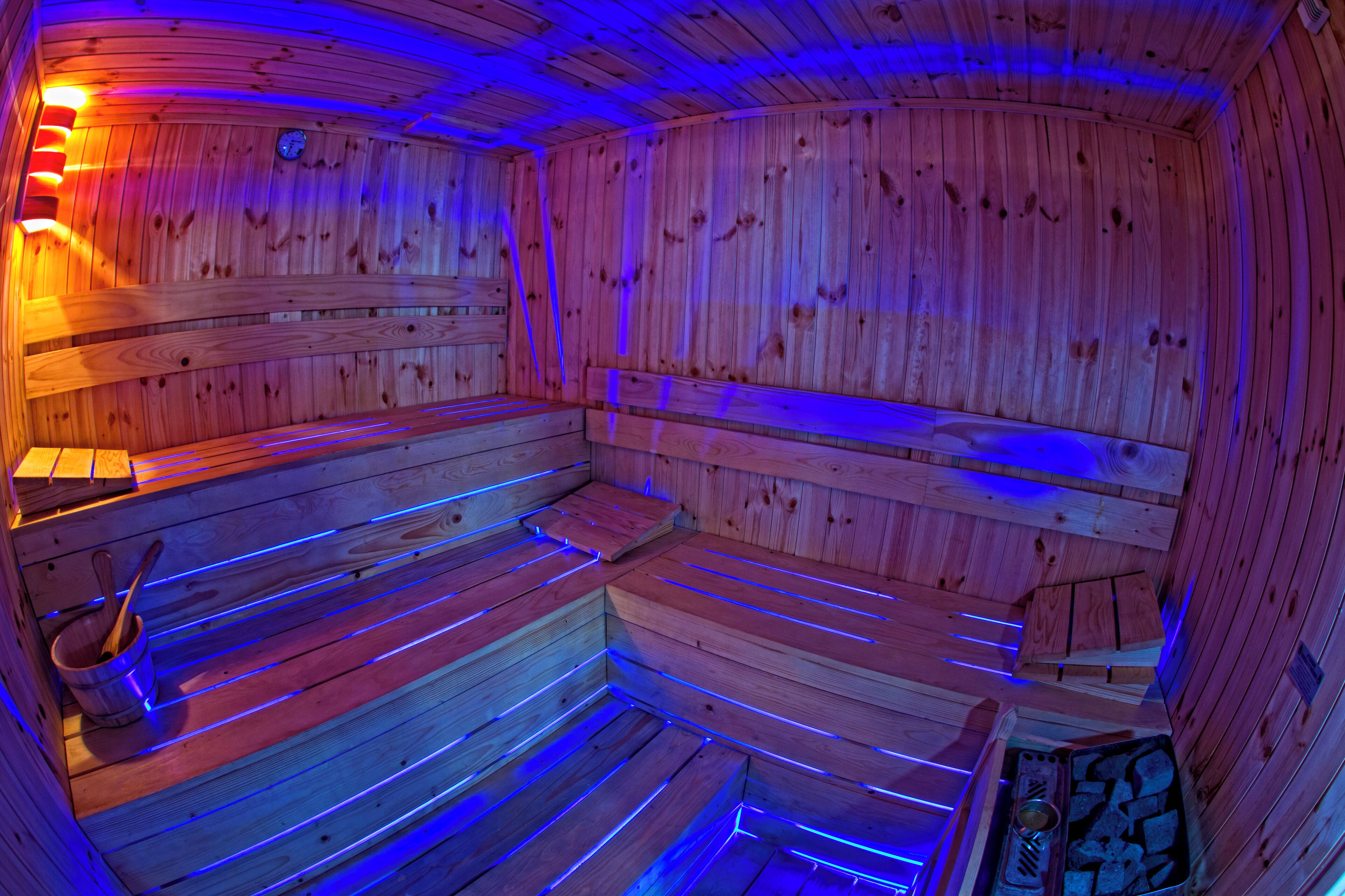 A sauna with wooden benches and a bench heater.