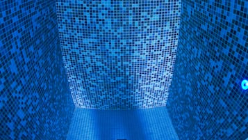 Unique mosaic tile design adorns the walls and ceiling, creating a visually striking pattern.