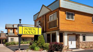 Experience the charm of a traditional Nordic-style lodge with a pitched roof and stone wall.