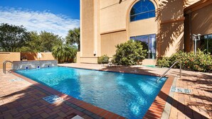 A rectangular swimming pool with a tiled edge, surrounded by a brick patio. - Best Western Casa Villa Suites (Harlingen)