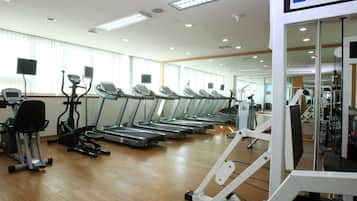 A gym with multiple treadmills, exercise bikes, and weight machines.