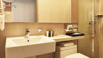 Un baño moderno con lavamanos, espejo, inodoro y ducha.